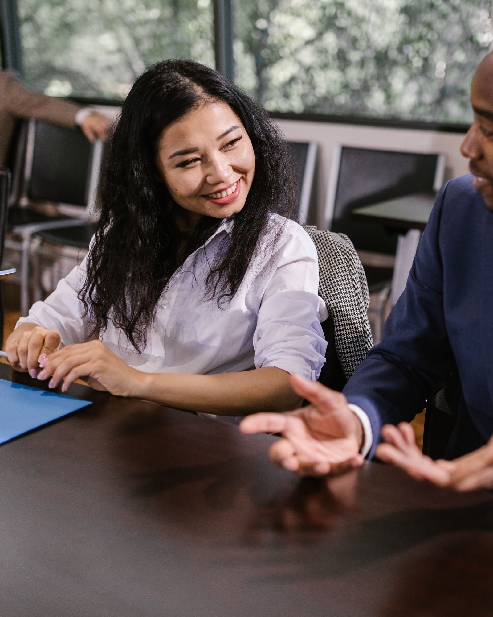 Two colleagues in conversation across a meeting table